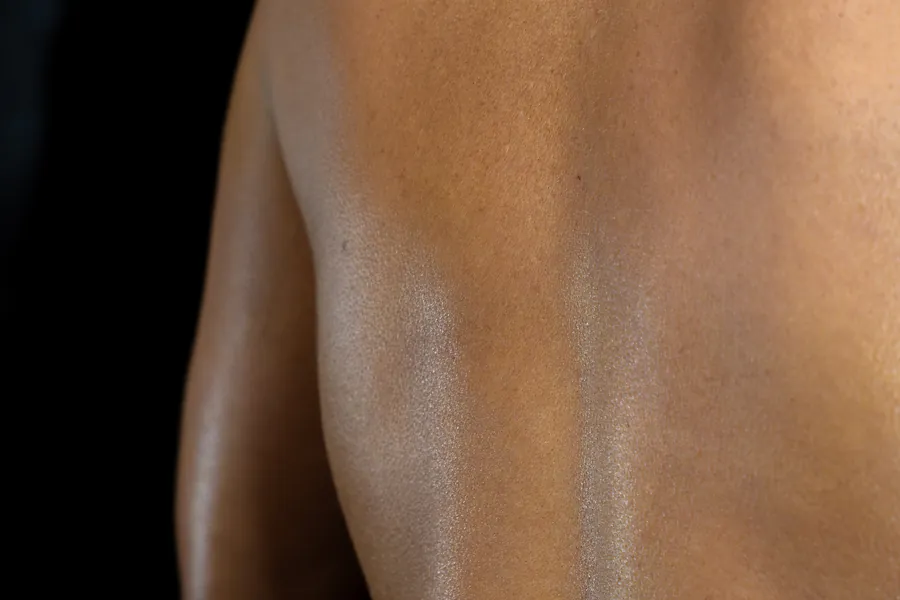 An even Dolce Glow tan across a guest's back, photographed at AWE