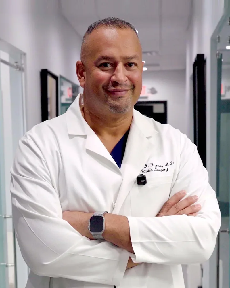 Dr. Jaime Flores, MD, in a white coat in the AWE hallway